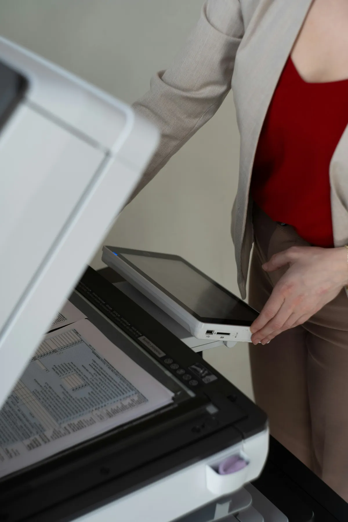 Frau legt ein Dokument in den Scanner-Dokumentenfeeder