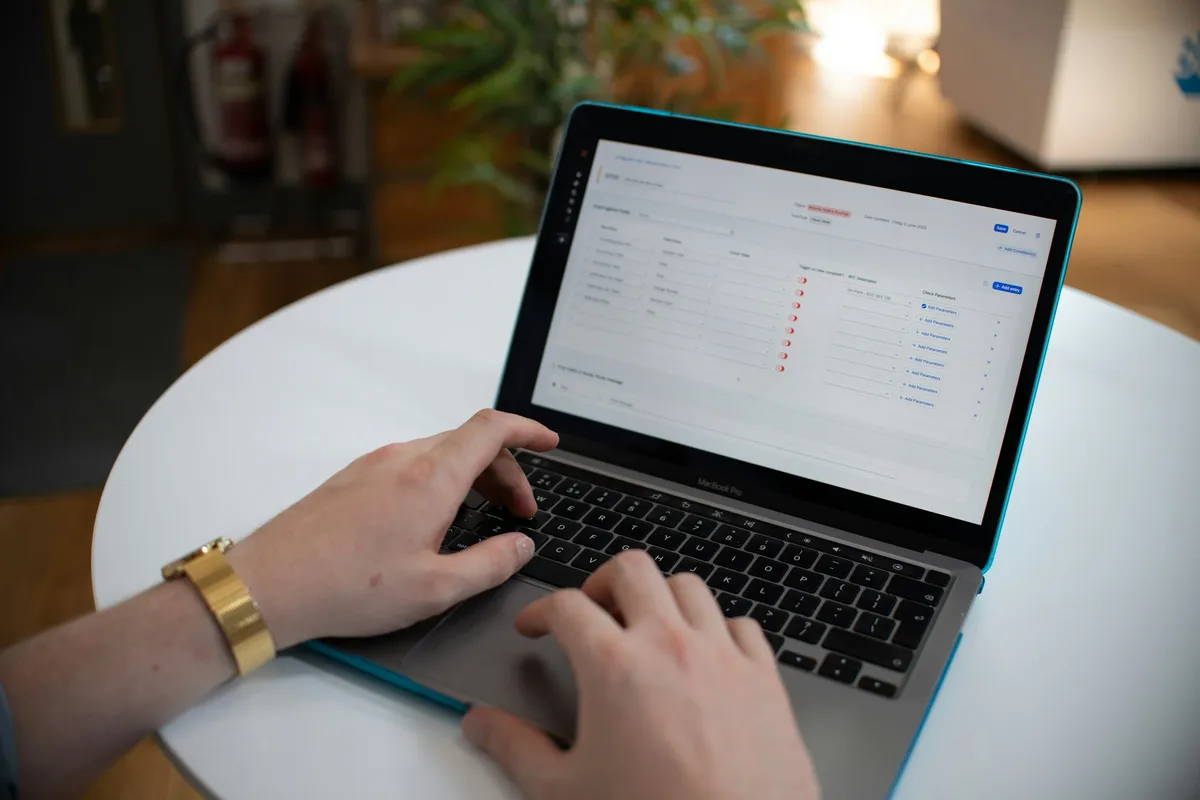 Hände tippen auf einem Laptop mit einer Tabelle auf dem Bildschirm